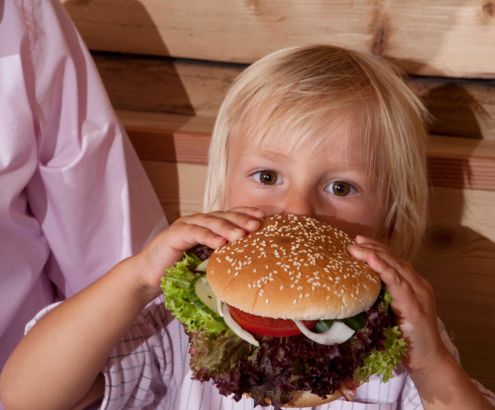 Kind beim Burger essen im Familienhotel Hinteregger