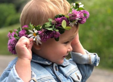 Kleines Kind mit Blumenkranz am Kopf