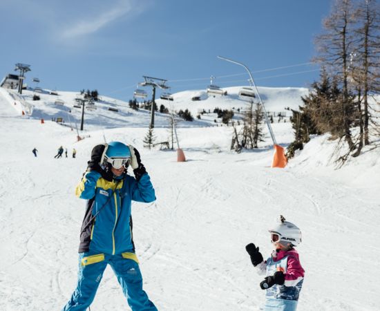 Skilehrer mit Kind im Skikurs